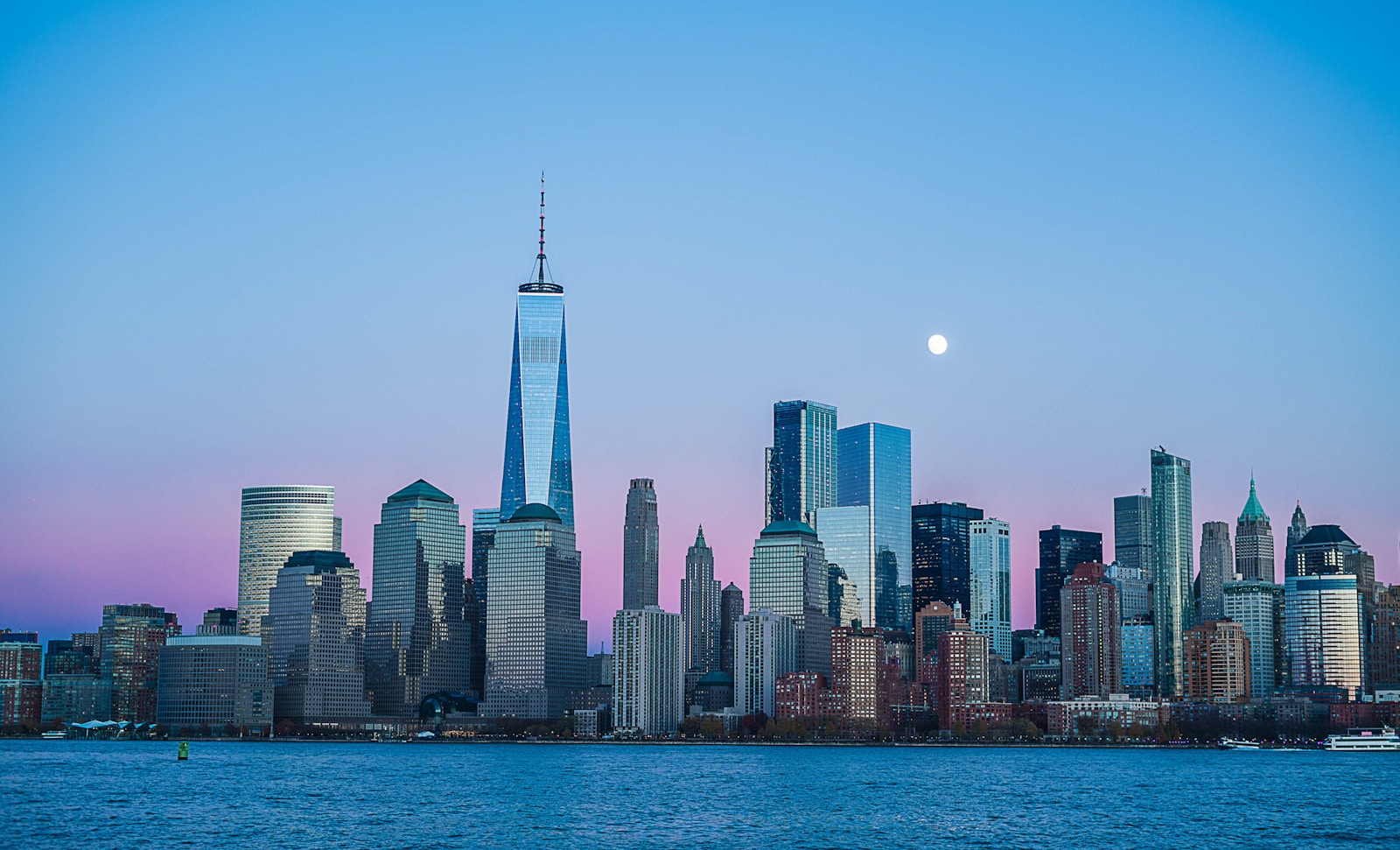 City skyline at dusk with the moon rising